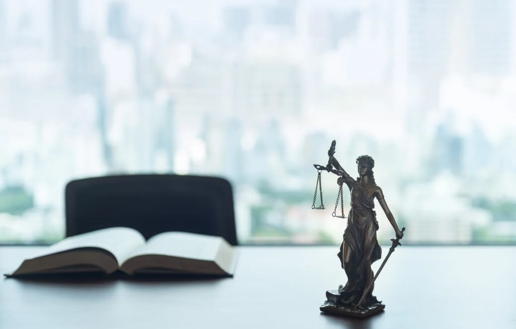 Statue of Lady Justice beside an open law book, symbolizing legal guidance and professionalism for real estate and business law in Salisbury, MD.