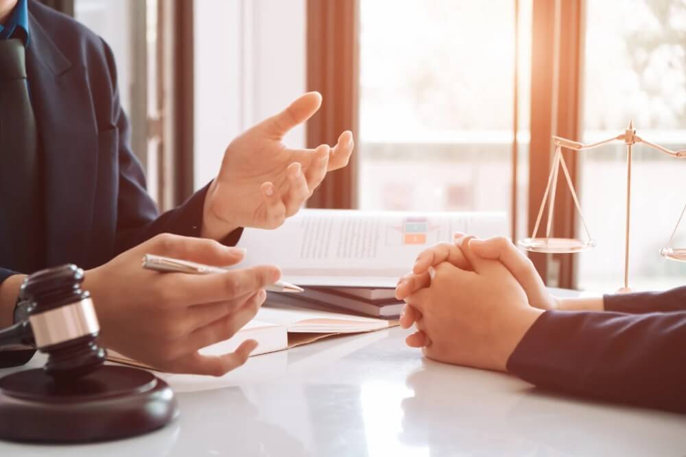 Attorney discussing legal matters with a client, gavel and scales of justice on the table, emphasizing estate planning and legal guidance in Maryland.